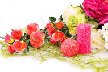 Colorful roses and candles on white background.