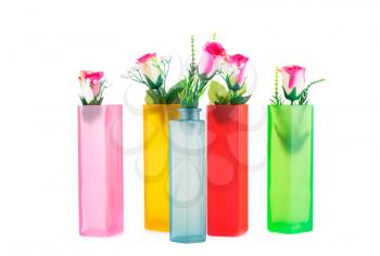 Colorful fabric roses in glass vases isolated on white background.