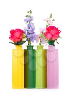 Colorful fabric flowers in glass vases isolated on white background.