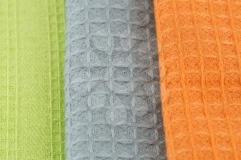 Stack of colorful kitchen towels closeup picture.