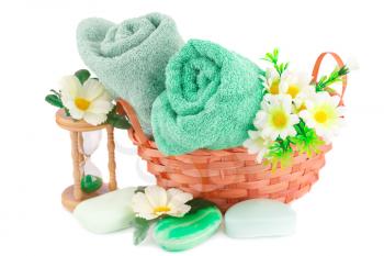 Spa set with towels, soaps, sandglass  and flowers isolated on white background.