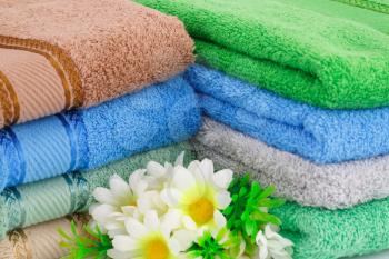 Colorful towels stack  and flowers closeup picture.