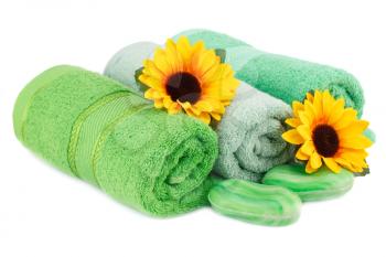 Rolled towels, soaps and flowers isolated on white background.