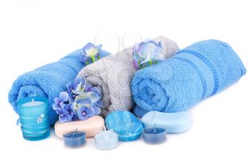 Spa set with towels, candles, flowers and various soaps isolated on white background.