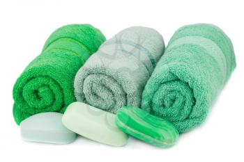 Rolled green towels  and soaps isolated on white background.