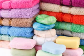 Colorful towels stacks and soaps closeup picture.