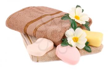 Folded towel, soaps and flowers isolated on white background.