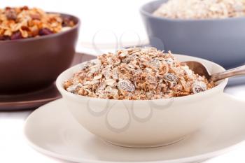 Muesli in the bowls on white background.
