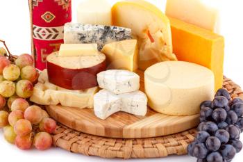 Various type of cheese,wine and grapes on wooden board closeup picture.
