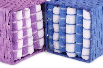 Pink, blue and white folded towels in boxes on white background.