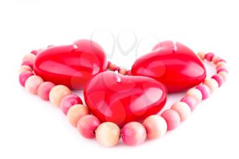 Red heart candles and wooden necklace isolated on white background.