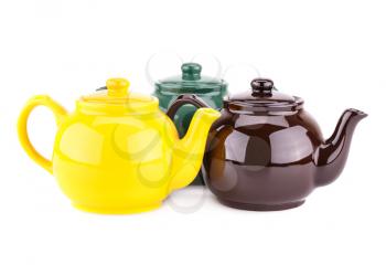 Green, yellow and brown teapots isolated on a white background.