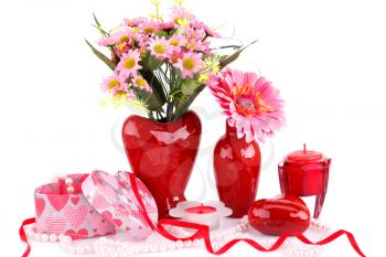 Flowers in vases, red heart glass, necklace, gift box and candle isolated on white background.