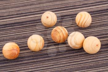 Wooden balls on striped fabric background.