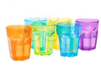 Colorful plastic glasses with water isolated on white background.