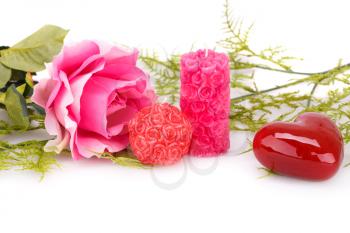 Candles, pink rose, glass heart and leaves  isolated on white background.