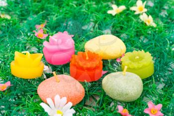 Colorful candles on artificial grass background.