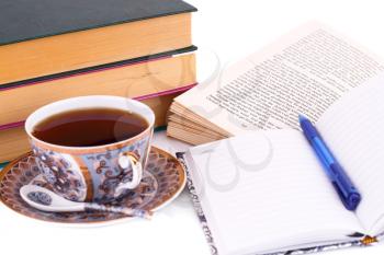 Books, cup of tea, note-pad and pen on white background.