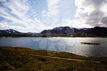 Landscape with mountains, lake, sky and clouds in Norway.