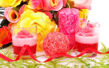 Colorful flowers and candles closeup image.