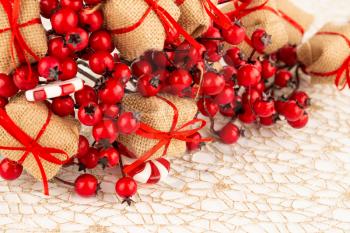 Christmas decoration with burlap gifts, holly berries  and candy on the golden net.