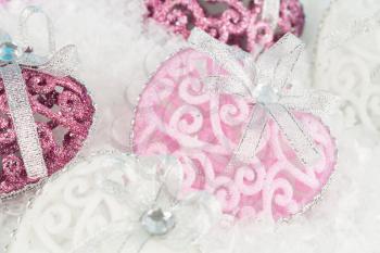 Christmas decoration with heart toys on the artificial snow background.