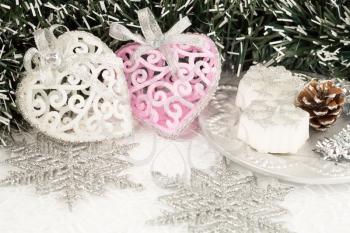 Christmas decoration with garland, hearts, candles and snowflakes on the shining net background.