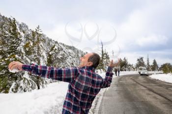 Winter scene with road on Troodos mountains in Cyprus. The man throwing the snowballs.
