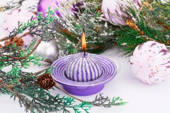 Christmas pink balls, candle and fir tree on gray background.