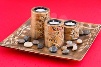 Three brown ancient style candle nests in plate on cloth background.