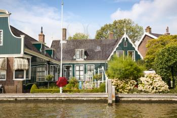 Traditional, authentic dutch houses and flowers at the canal.