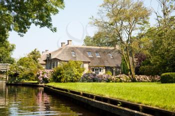 The thatched roof house with beatiful garden in fairy-tale village Giethoorn in The Netherlands.
