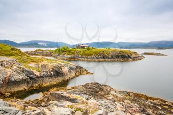 Landscape with fjord, rocks, small islands and mountains in Norway.