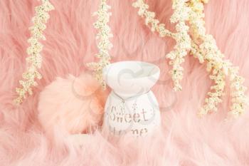 Home decorative with aroma lamp, candle and  white flowers on pink fur background.