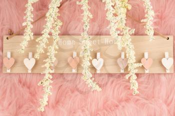 Decorative wooden board with words Home, Sweet Home  and white flowers on pink fur background.