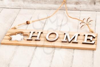 Wooden sign with word Home on gray board background.