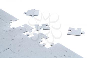 Unfinished jigsaw puzzle pieces on white background.
