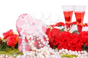 Two glasses, flowers, colorful pearls necklaces and gift box on white background.