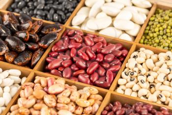 The collection of different beans in the wooden box.