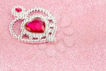 Jewelry heart with stones on pink sparkling background.
