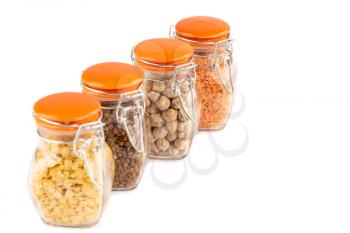 The collection of different groats in the glass jars isolated on white background. Buckwheat, chickpea and lentils.