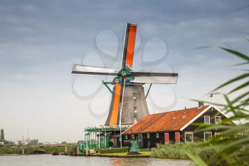 Traditional, authentic dutch windmills at the river Zaam in Zaanse Schans village.