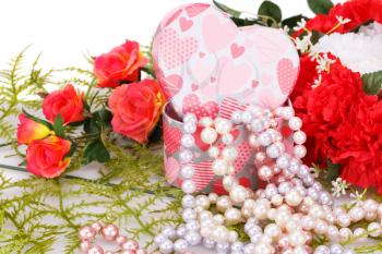 Flowers, colorful pearls necklaces and gift box on white background.