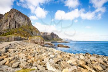 Landscape with high rocky mountains, road and fjord in Hamnoya, Norway.