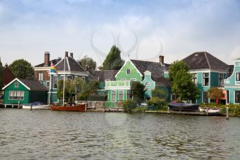 Traditional, authentic dutch houses and boats at the canal.
