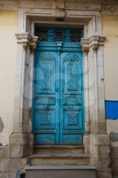 Old wooden door with metallic ornament in Limassol, Cyprus.