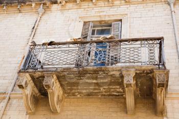 Old building with beautiful balcony and cats in Limassol, Cyprus.