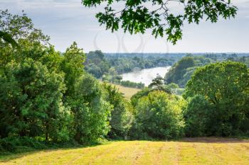 View of Thames river from Richmond Park, UK. Landscape with trees and field in sunny summer day.