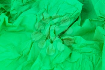 Crumpled green crepe paper texture as a background.