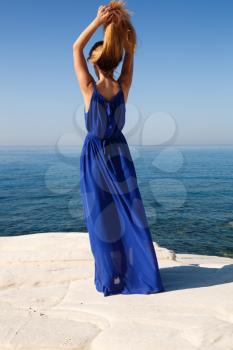 Pretty blond woman in the blue dress at the beach in Cyprus.